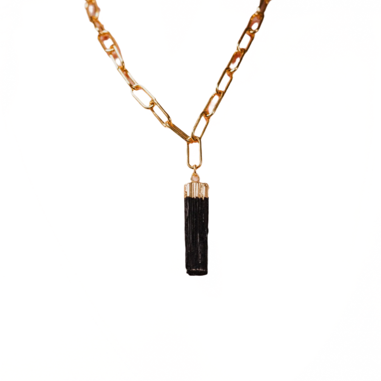 Gold chain necklace with a black tassel pendant on a white background