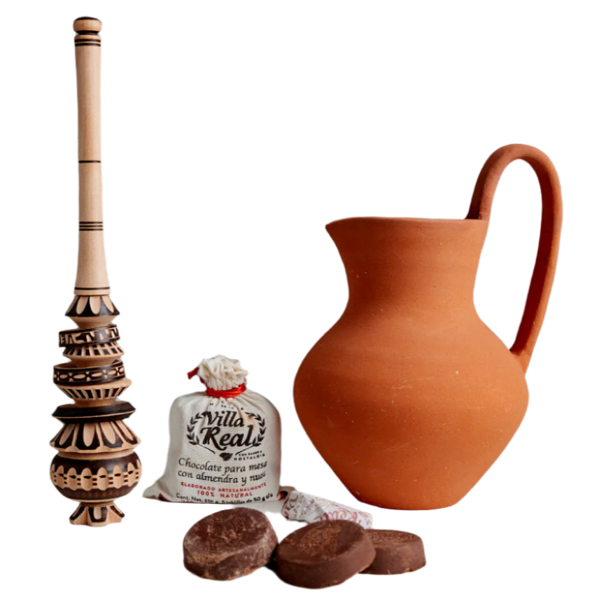 Terracotta pitcher, wooden brush, and chocolate truffles on a white background