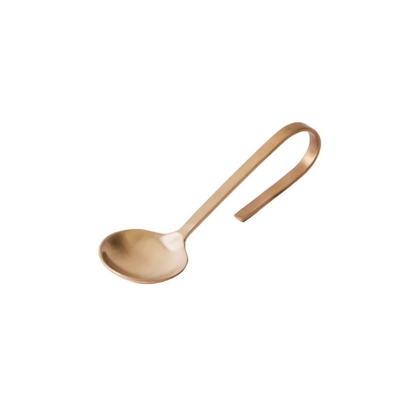Gold spoon on a light beige background