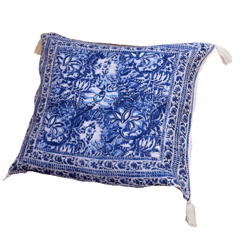 Blue patterned throw blanket with tassels on a wooden chair against a yellow wall.