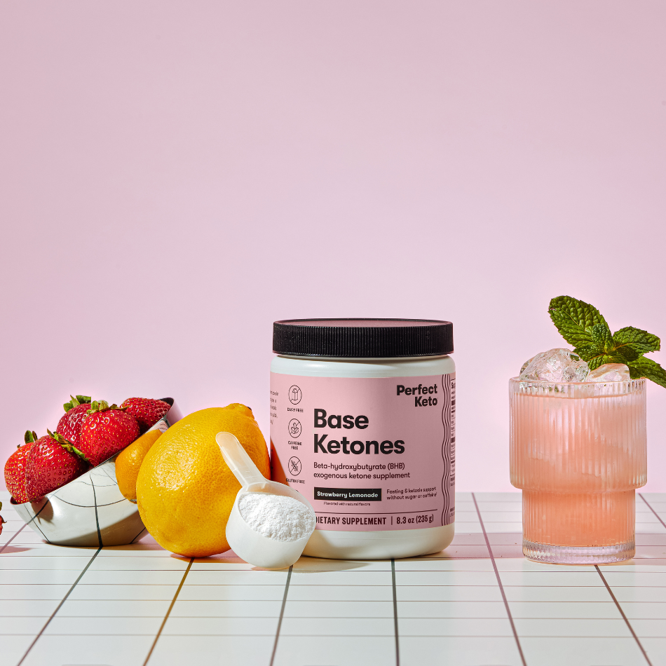 Perfect Keto Base Ketones container with strawberries, lemon, and a cocktail on a pink background