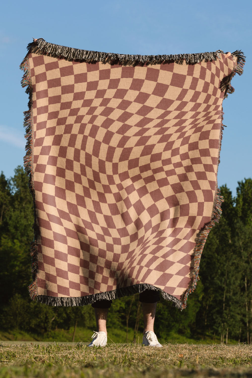 Trippy Checkers Brown Cotton Woven Throw Blanket with a psychedelic checker pattern and fringe edges.
