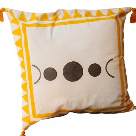 Decorative pillow with moon phases and tassels on a wooden surface