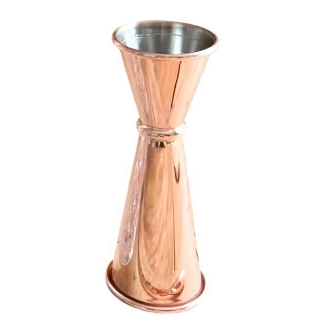 Rose gold jigger and clear glass on a wooden surface