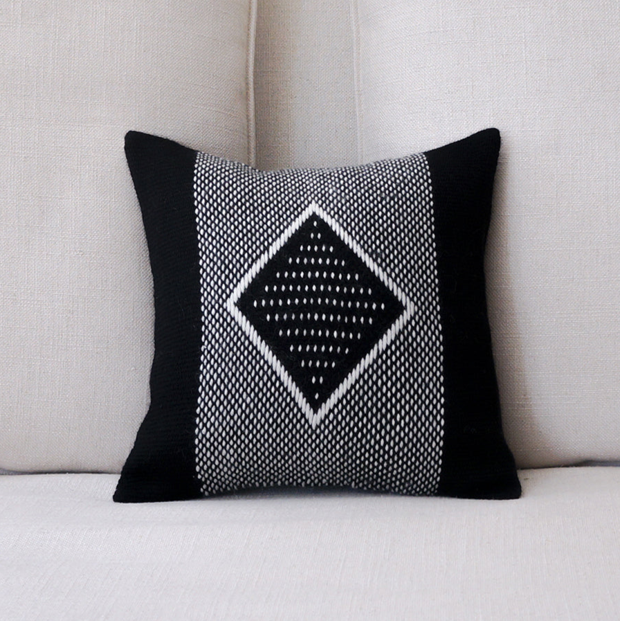 Decorative pillow with black and white pattern on a beige sofa