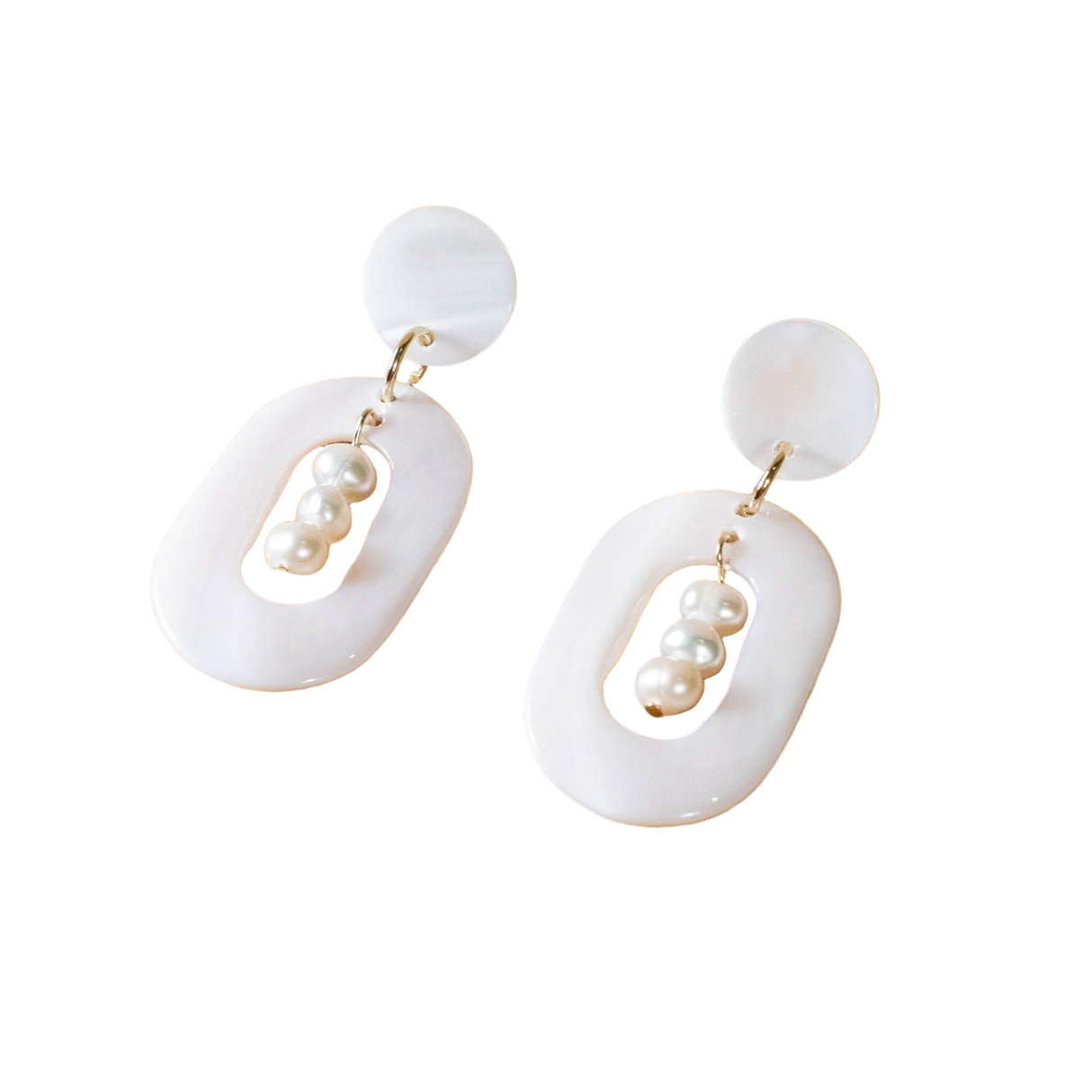 Pair of earrings with white circular pendants and pearl-like beads on a white background