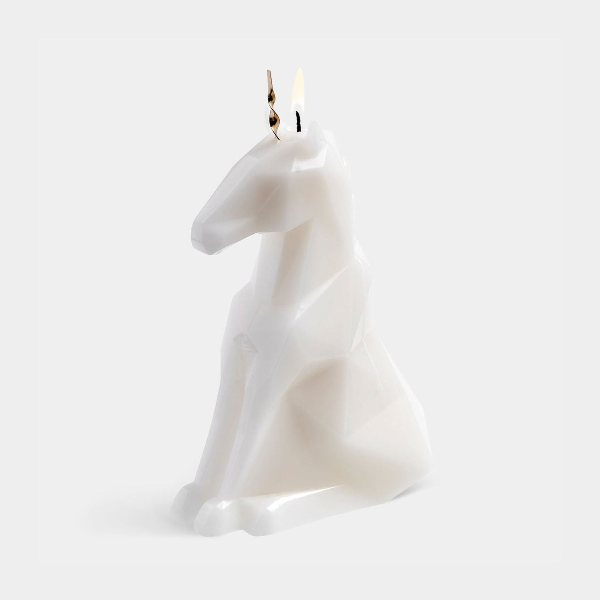 Unicorn-shaped candle on a white background