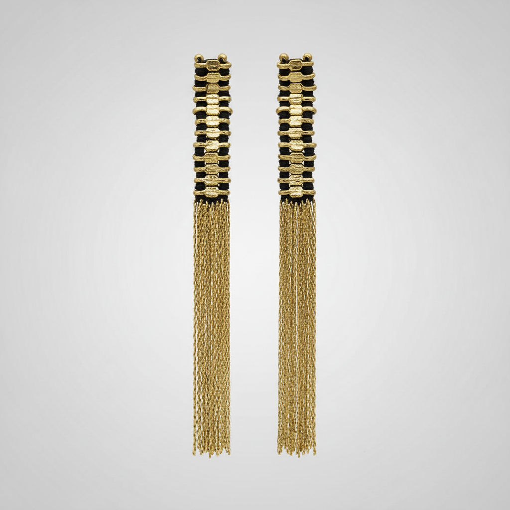 Pair of gold tassel earrings on a light gray background