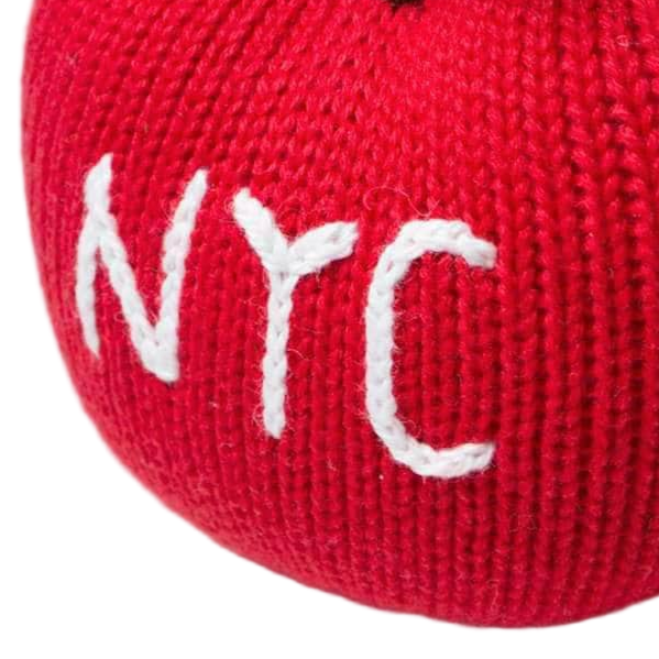 Red knitted apple with 'NYC' embroidered on a white background