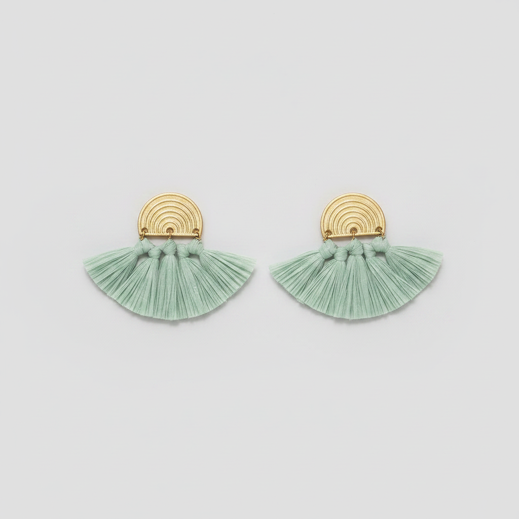 Pair of green tassel earrings with gold accents on a light gray background
