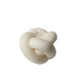 White knot-shaped candle on a white background