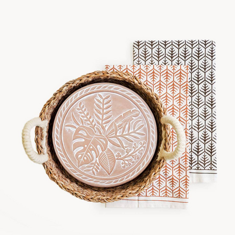 Decorative plate with leaf pattern in a woven basket on a white background