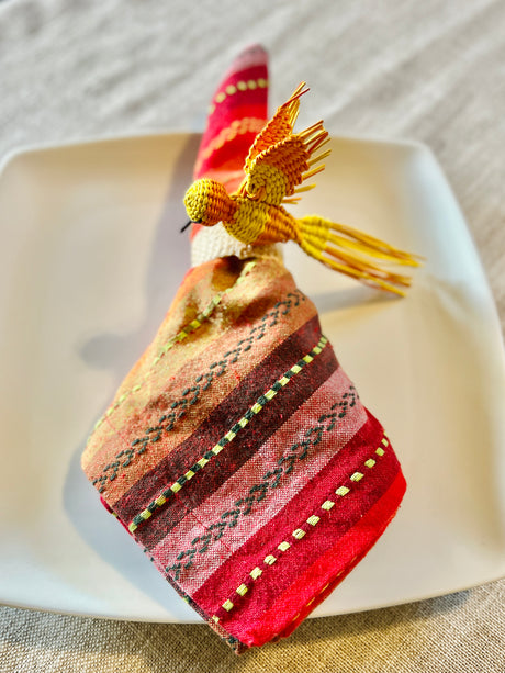 Decorative napkin ring with bird design on a white plate