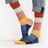 Colorful patterned socks worn with rolled-up jeans on a white background