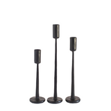 Three black candle holders of varying heights on a white background