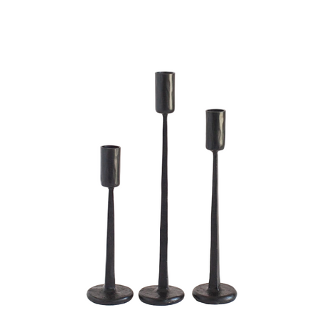 Three black candle holders of varying heights on a white background