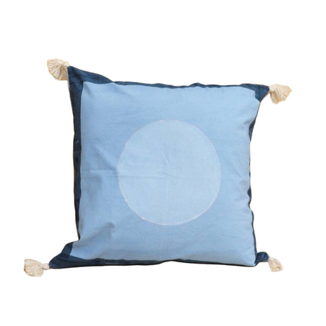 Blue pillow with a white circle design on a decorative wall background