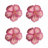 Four pink flower-shaped napkin rings on a white background