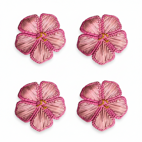Four pink flower-shaped napkin rings on a white background
