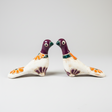 Two ceramic birds with floral designs on a white background