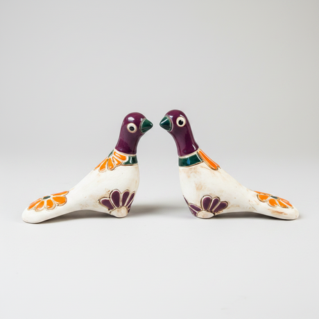 Two ceramic birds with floral designs on a white background