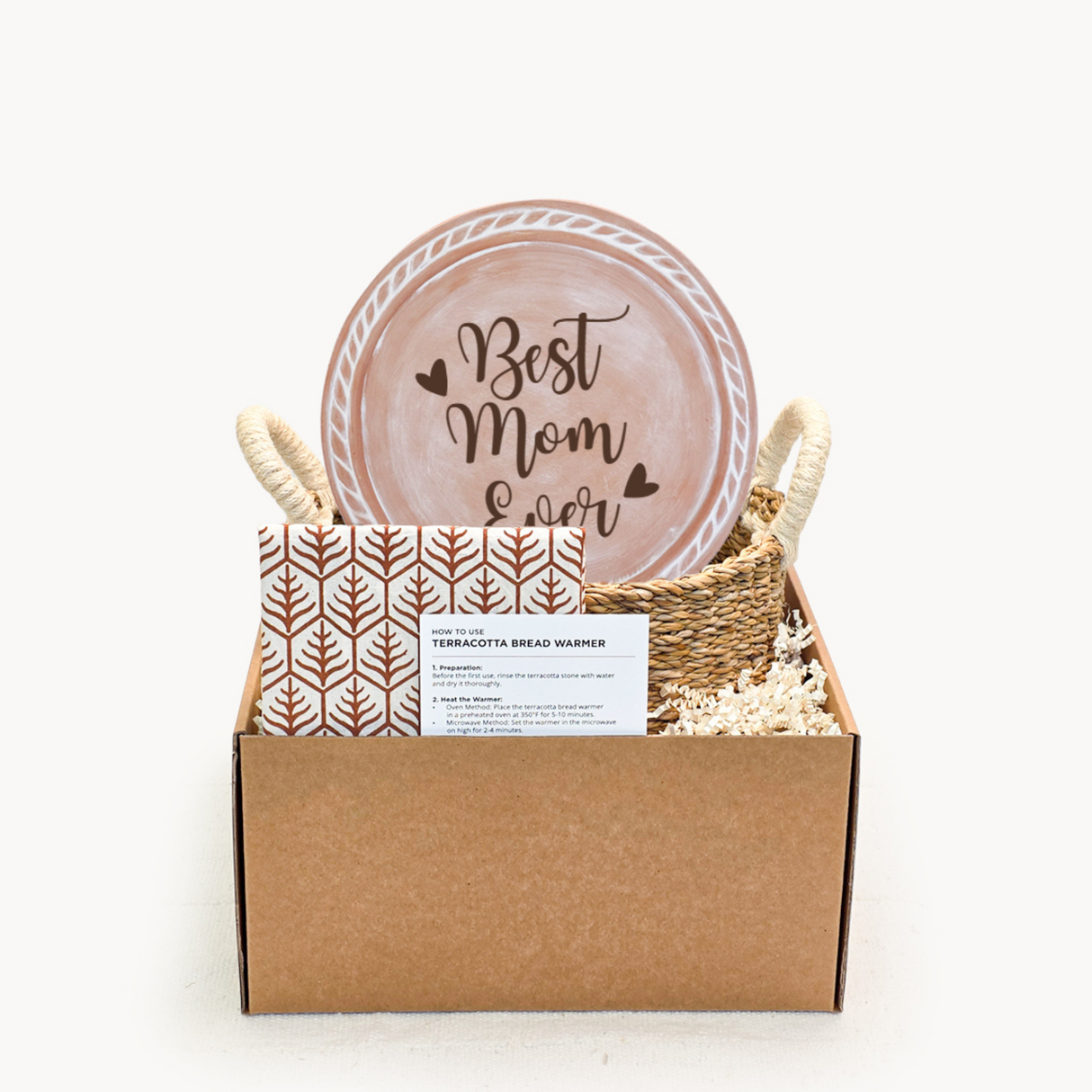 Gift set with 'Best Mom Ever' plate, bread warmer, and card in a box on a white background