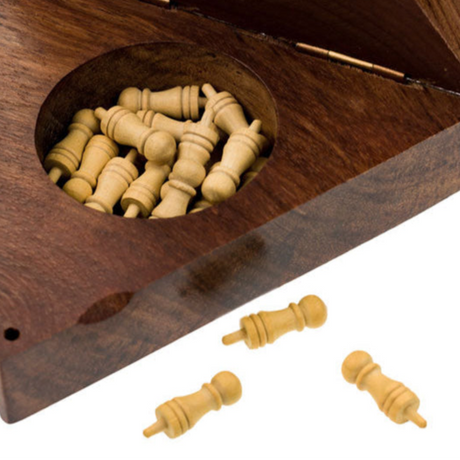 Wooden chess pieces in a wooden box with additional pieces on a white background