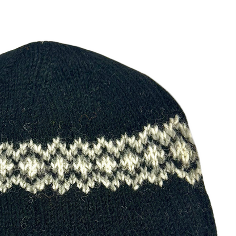Black knit beanie with white pattern and Sherpa logo on a white background