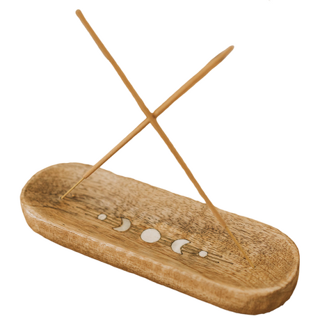 Wooden incense holder with sticks on a wooden surface
