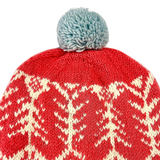 Red knit beanie with white pattern and gray pom-pom on a white background