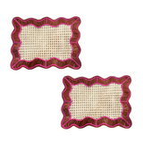 Two woven placemats with pink and brown frames on a white background