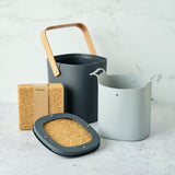 Three containers with a sponge on a light gray surface
