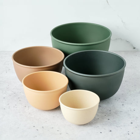Set of five bowls in different colors on a light gray surface