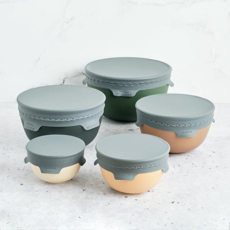 Set of silicone food containers with lids on a light surface