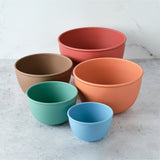 Set of five colorful bowls on a light gray surface with a white background