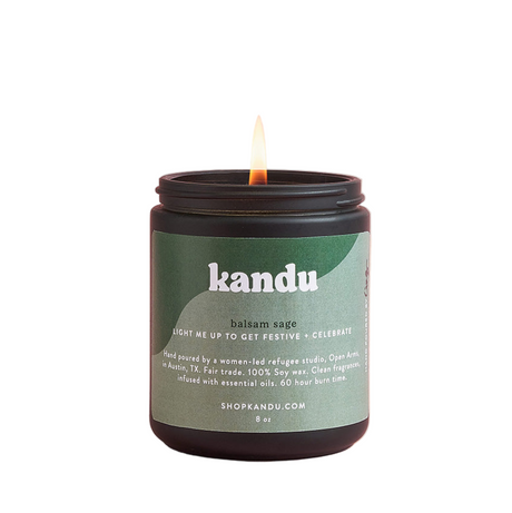 Kandu candle with a lit wick on a white background