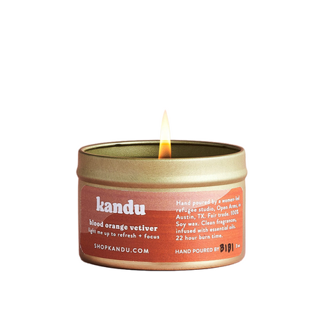 Kandu candle with a lit wick on a white background