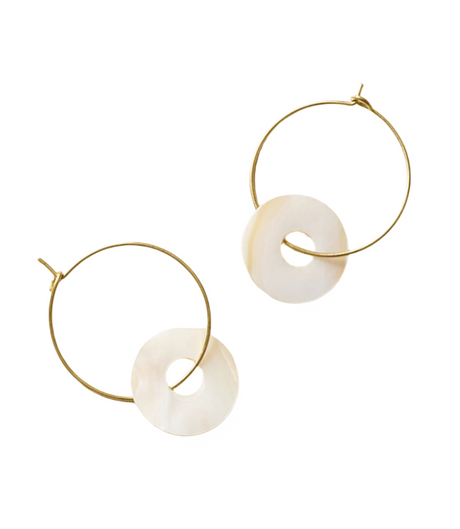 Gold hoop earrings with white circular stones on a beige background