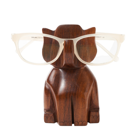 Wooden elephant-shaped glasses holder with a pair of glasses on a white background