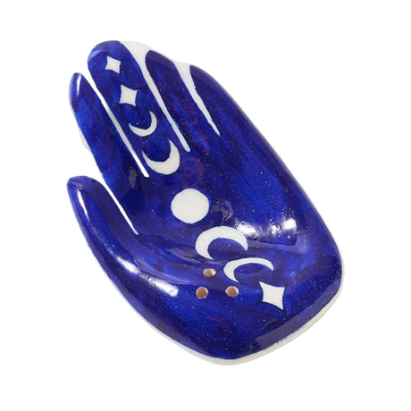 Blue ceramic hand-shaped dish with white designs on a white background