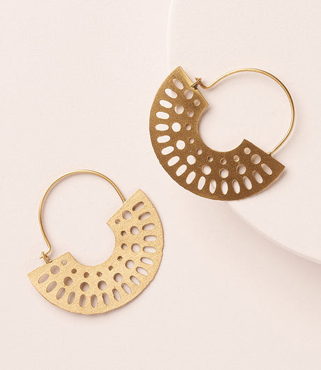 Gold hoop earrings with intricate cut-out designs on a light background