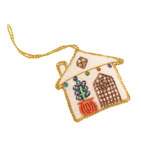 Decorative house-shaped ornament with beaded details on a white background