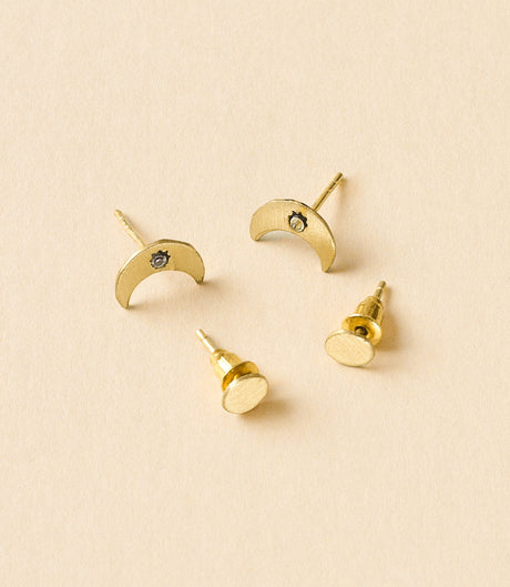 Set of gold earrings on a beige background