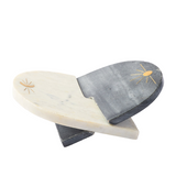 Two marble cutting boards with sun designs on a white background