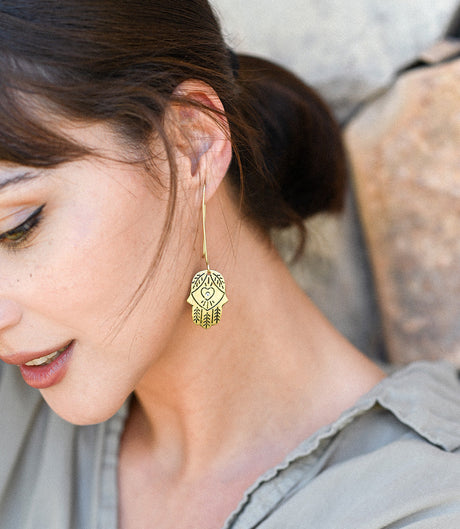 Close-up of a woman wearing a gold earring with a heart design.