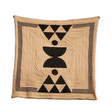Beige quilt with black geometric patterns on a stone ledge against a blue sky.
