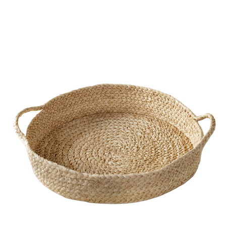 Woven basket with handles on a white background