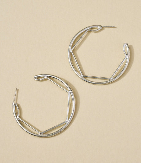 Pair of silver hoop earrings on a beige background