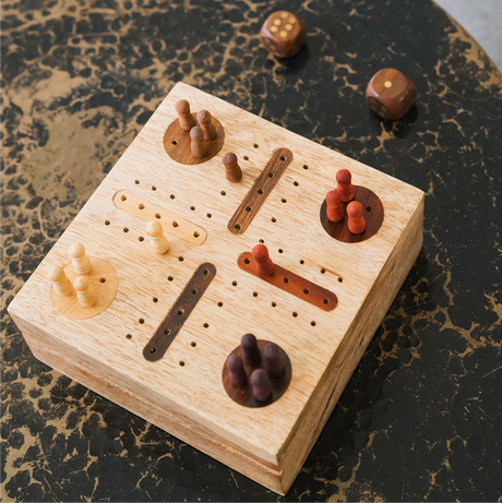 Wooden pegboard game with pegs on a marble surface