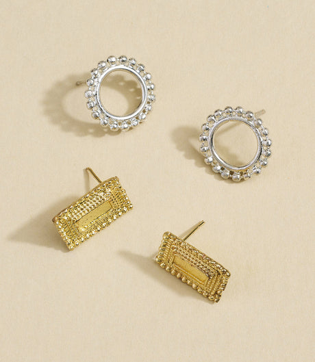 Set of gold and silver hoop earrings on a beige background